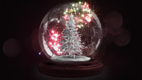 Animation-of-falling-stars-and-snow-globe-with-christmas-tree-over-fireworks-on-dark-background