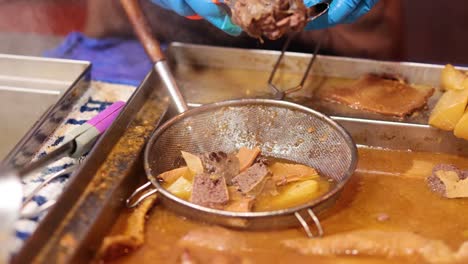 chef handling offal in a steaming broth