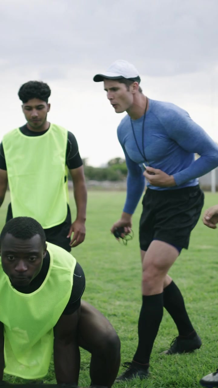 Giocatori di rugby che eseguono esercizi di ribaltamento pneumatici durante un allenamento all'aperto