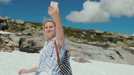 Una-Mujer-Feliz-Haciendo-Selfie-En-Un-Glaciar-En-Noruega-Cuando-Hace-Calor-Pero-La-Nieve-Aún-No-Se-Ha-Derretido