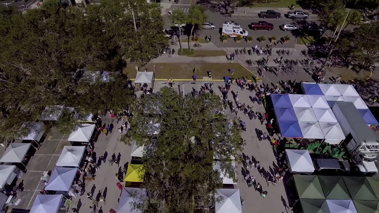 video de drones aéreos de 4k del mercado de agricultores en el parque frente al mar en st