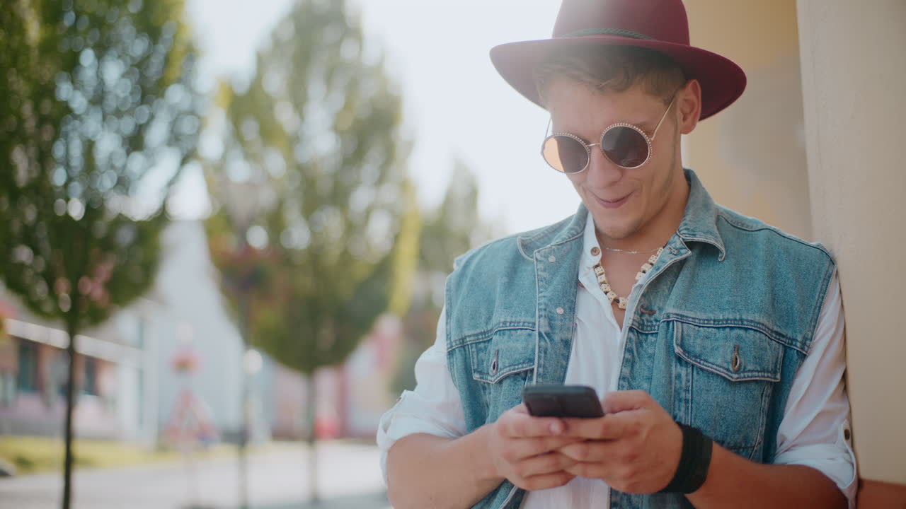 hombre elegante usando teléfono inteligente al aire libre