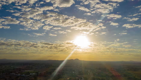 aerial hyperlapse of bright sunrise with fluffy clouds over california city