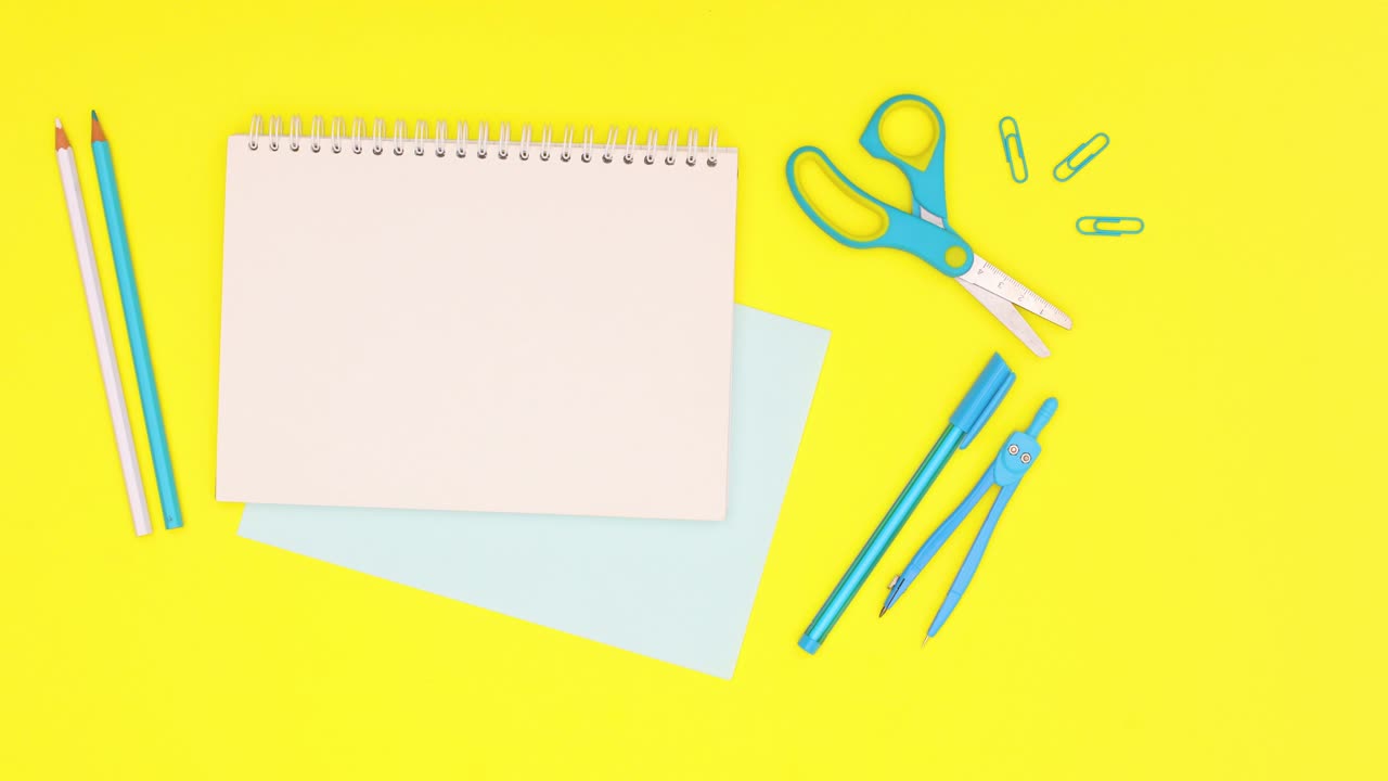 escritorio azul y papelería escolar moviéndose alrededor de cuaderno abierto. detener el movimiento