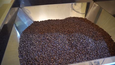 Massive-industrial-machine-of-coffee-beans,-handheld-view