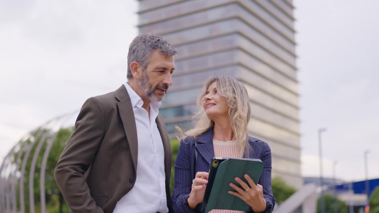 Business professionals collaborating with digital tablet outdoors