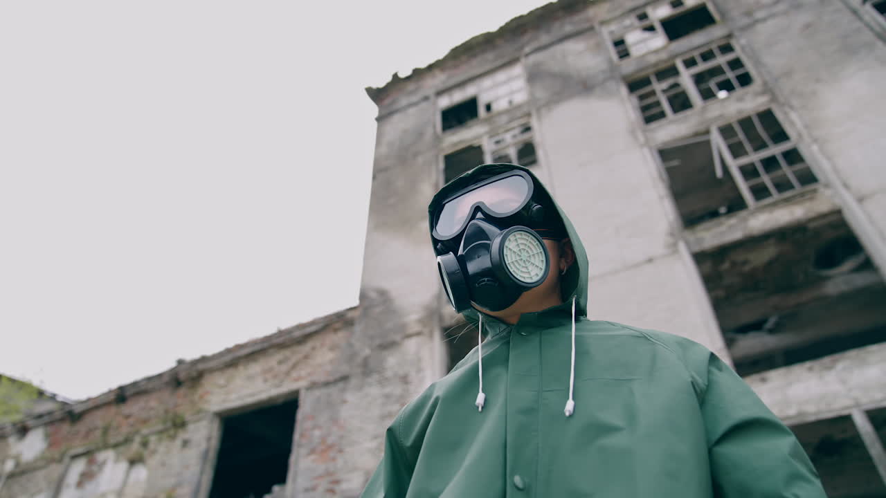 Woman in safety suit and respirator. Person in protective uniform during chemical attack in abandoned place. Nothing to breathe. Pollution of the environment.