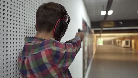 rare view of a man practicing with gun in the shooting range