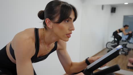 mujer haciendo ejercicio en una bicicleta estacionaria en un gimnasio personal