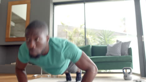 strong and fit african american man doing push-ups in living room for exercise