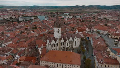 a historic european city with a large church in the center and surrounding rooftops, aerial view