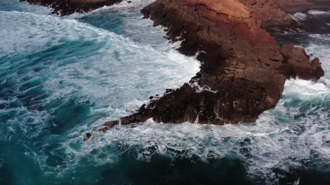 Vista Aerea con Drone delle Onde dell'Oceano che si Infrangono su un Molo in una Piccola Città a Lanzarote, nelle Isole Canarie