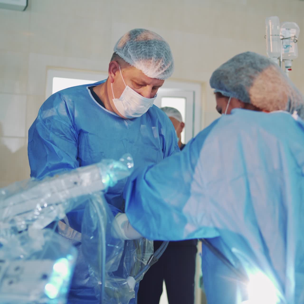 Surgeons prepare medical equipment in operating room. Surgery instruments in doctor's hands. Robotic machine. Medicine health care and treatment for saving life.