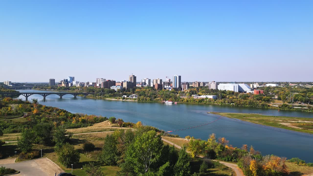 Aerial establishing shows Saskatoon downtown bustling with bridges and river
