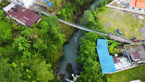 Toma-Aérea-De-Arriba-Hacia-Abajo-Del-Río-Que-Fluye-Con-Un-Puente-En-La-Ciudad-De-Pokhara-Durante-El-Día-Soleado,-Nepal