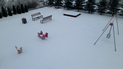 Aerial-shot-of-snow-covered-empty-playground-during-cold-winter-day-in-Poland