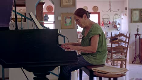 old woman playing a grand piano at her home