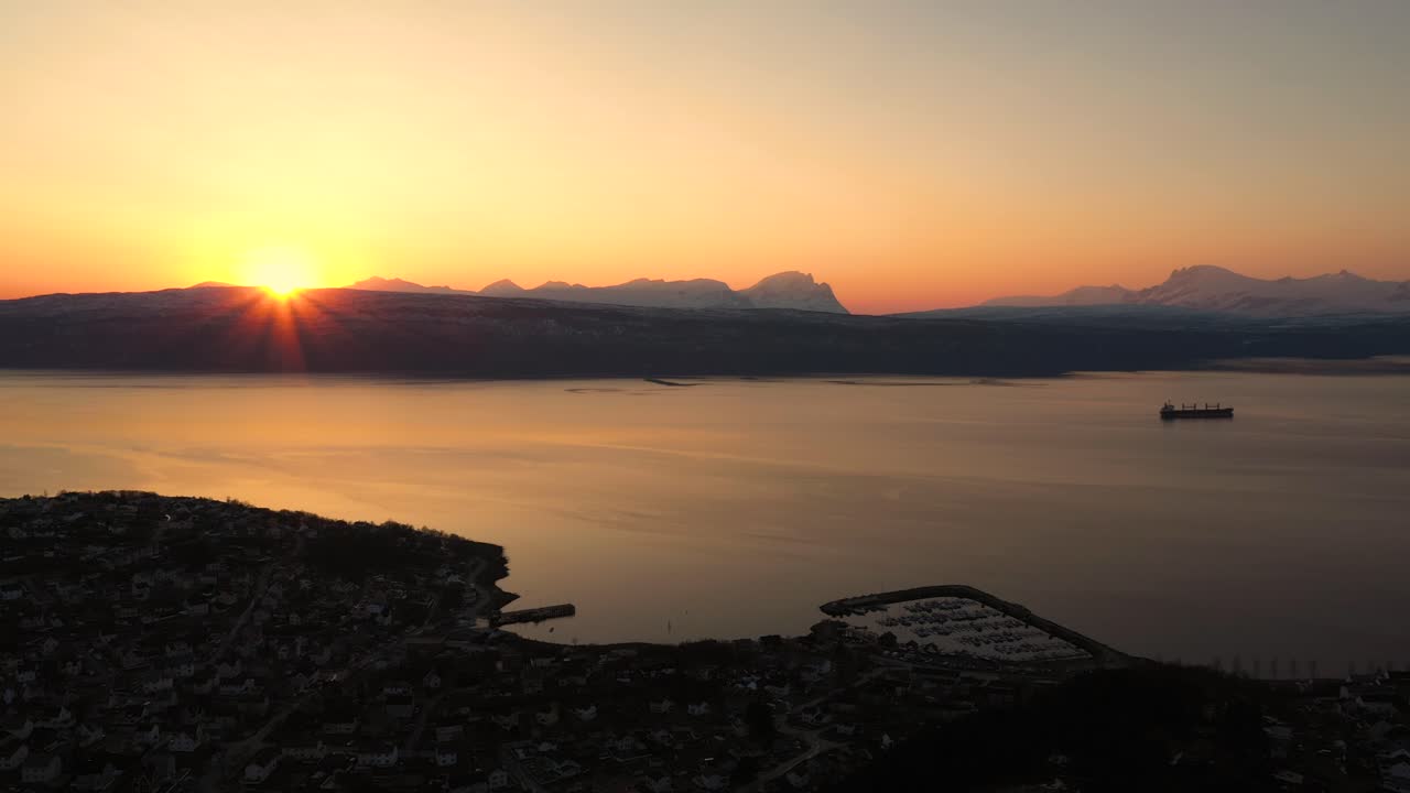 Vista aérea do pôr do sol sobre a cidade à beira-mar.