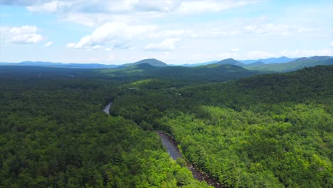 aerial footage over forest with river flowing in upstate new york on a nice summer day