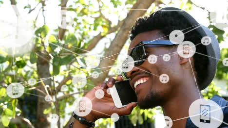 animation of african american man talking on smartphone over network of connections with icons