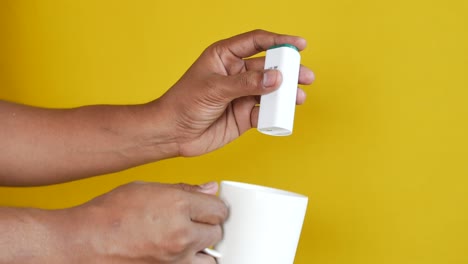 person holding a medical device and a white mug