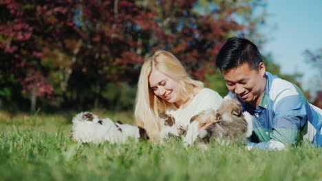 Couple-Playing-With-Puppies