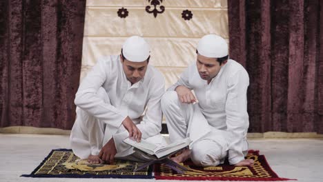 indian muslim men reading quran holy book