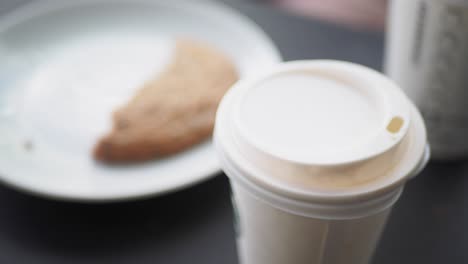 closeup of a coffee cup and a pastry on a plate