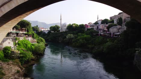 drone flying under old bridge in mostar at neretva river in bosnia and herzegovina