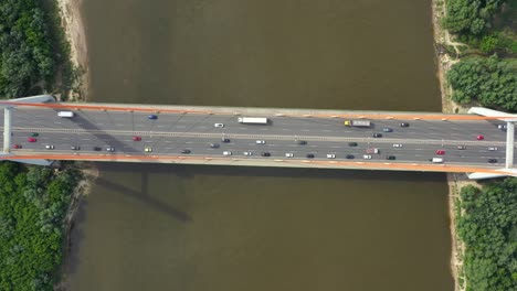 coche de la ciudad moviéndose en el puente de la autopista en la superficie del río suave de fondo vista de drones