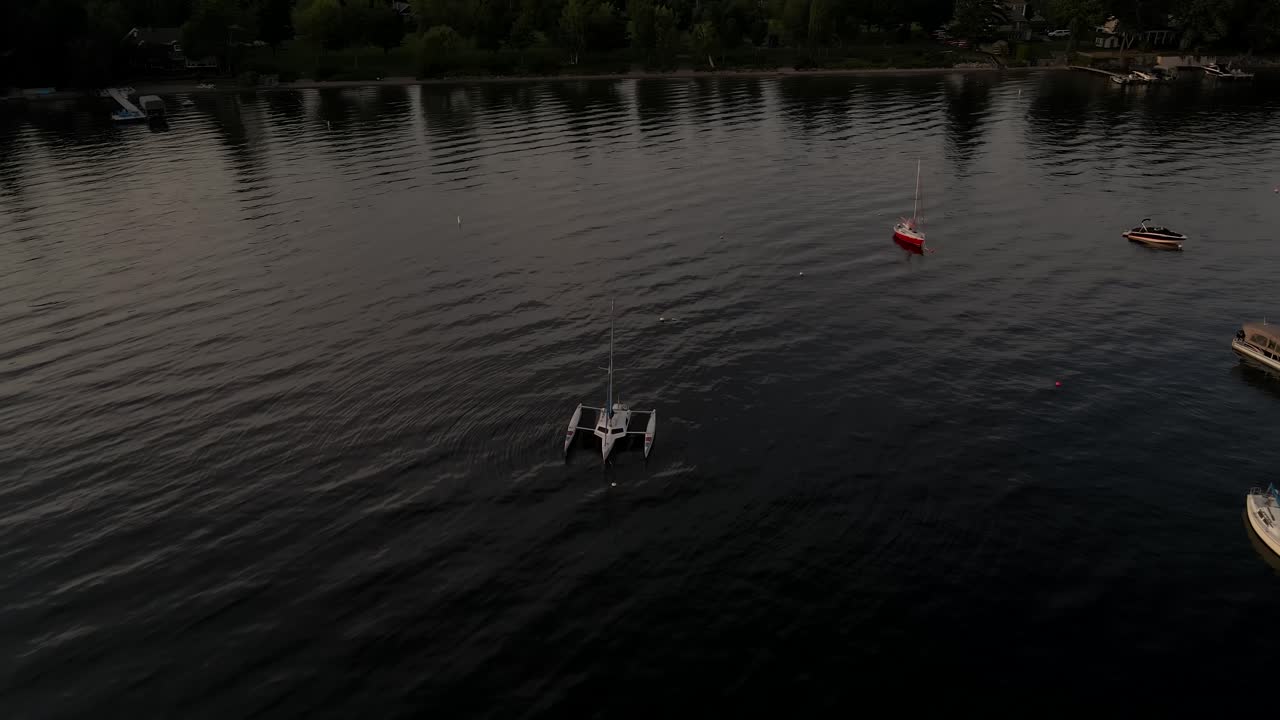 veleros y catamarán flotando en el lago memphremagog cerca de las casas frente al mar en quebec, canadá