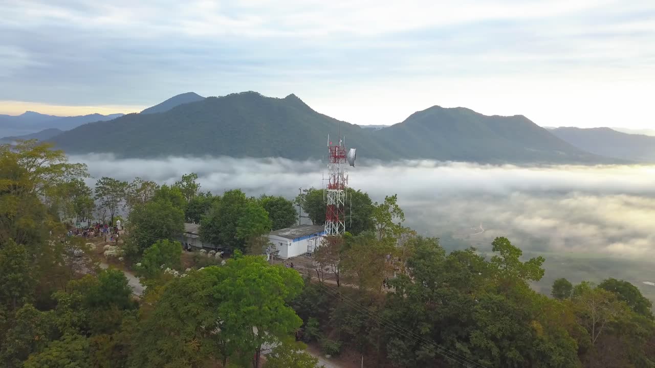 산과 반전이 있는 정상에서 무선 통신 타워 주변의 공중 궤도 샷