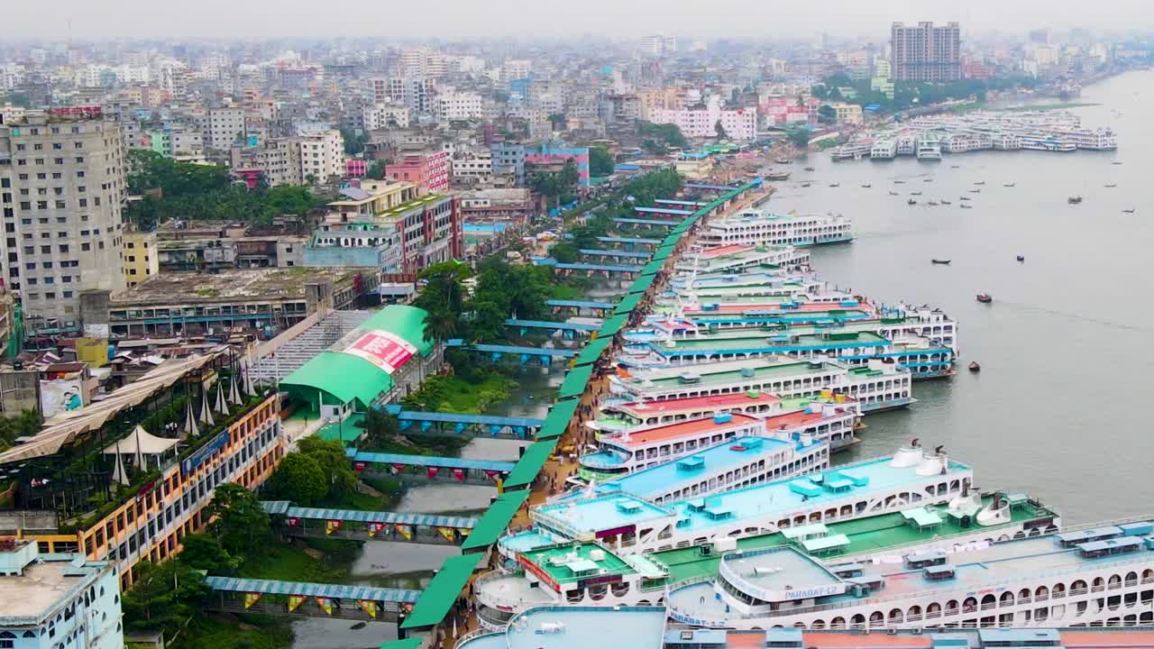 Veduta aerea verso le navi al più grande terminal per imbarcazioni di Sadarghat nel fiume Buriganga, Dhaka, Bangladesh - Ripresa aerea con angolazione elevata e movimento ascendente