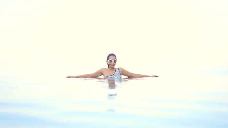 Schöne-Frau-Im-Tropischen-Paradies,-Die-Im-Infinity-Pool-Genießt,-Kollidierte-Mit-Der-Skyline