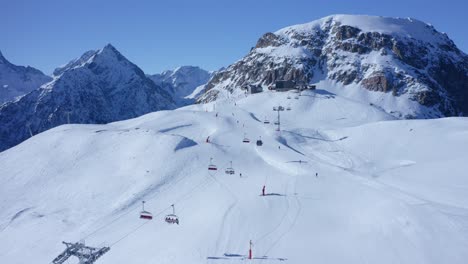 plataforma rodante aérea para revelar personas que descienden de una pista de esquí en lo alto de las montañas de canadá