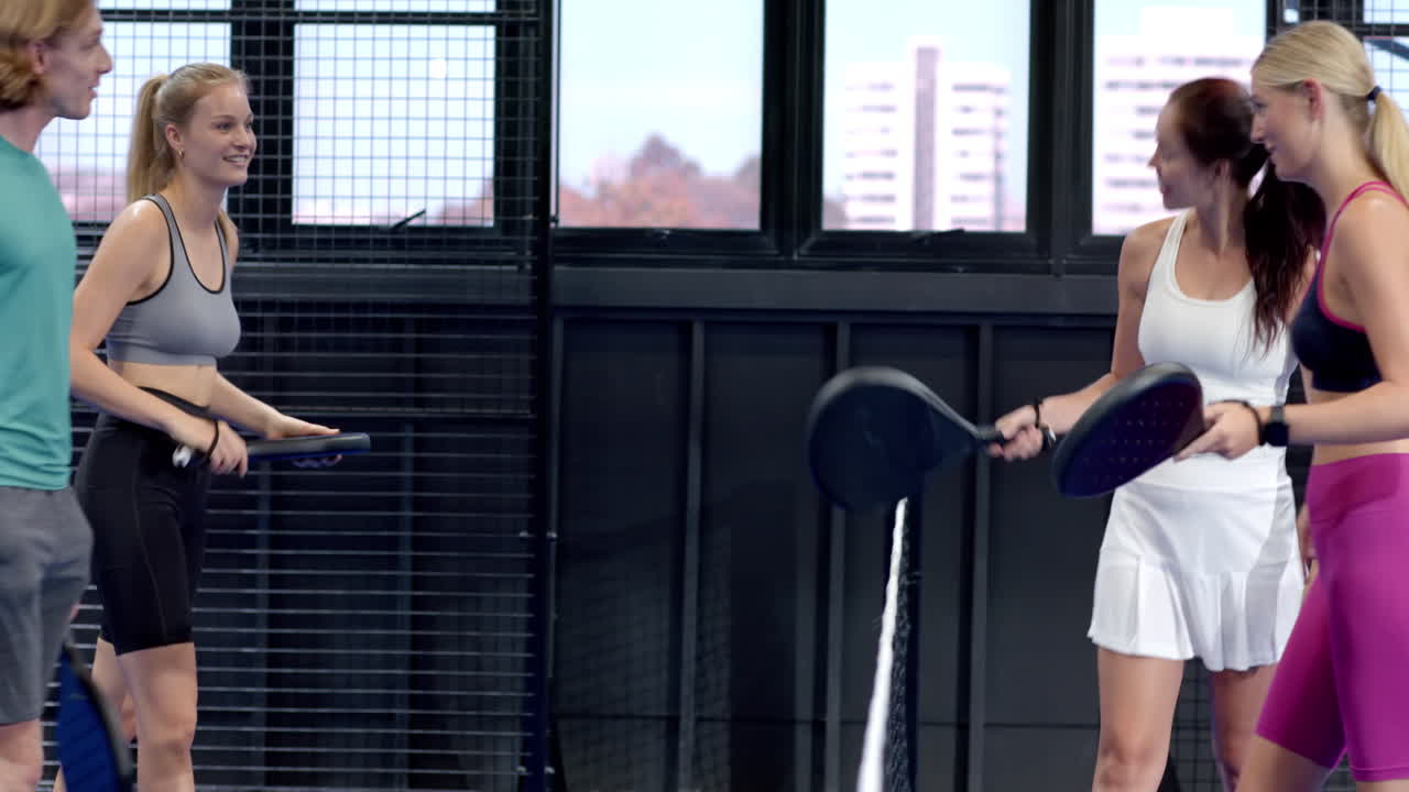 Young woman playing padel tennis, smiling and enjoying indoor court game