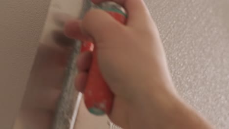 man plastering the walls with finishing putty in room with putty spatula