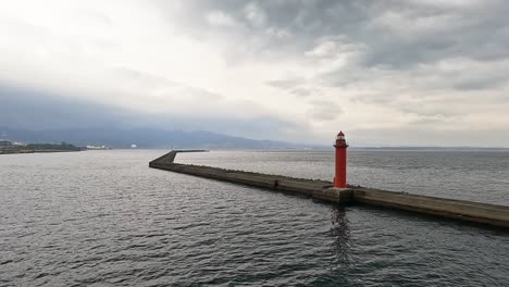 Vorbei-An-Einem-Roten-Leuchtturm-Auf-Einem-Wellenblocker-Im-Meer