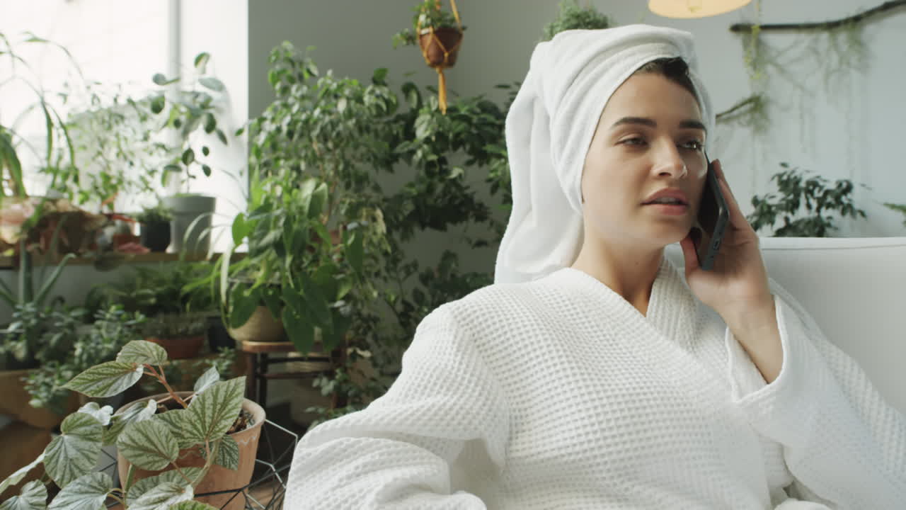 Woman in Bathrobe Chatting on Phone