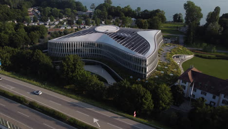 slow aerial tilt up shot above a motorway and the international olympic committee building in lausanne, switzerland