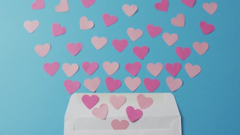 Sobre-Con-Corazones-De-Papel-Sobre-Fondo-Azul-En-El-Día-De-San-Valentín.