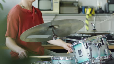 young man playing drums indoors