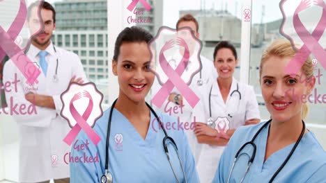 Animation-of-pink-ribbon-cancer-logos,-floating-over-smiling-group-of-male-and-female-doctors