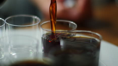 jägermeister being poured in slow motion into a row of shot glasses