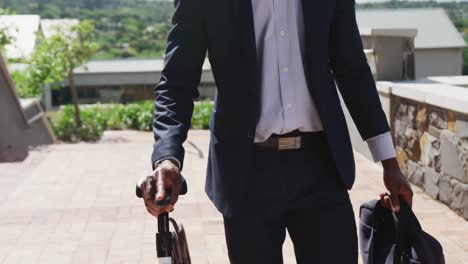 African-american-businessman-walking-and-holding-bike,-slow-motion