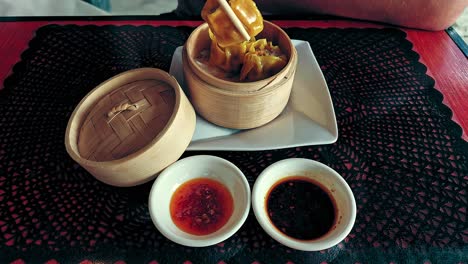 overhead view of a tourist foodie eating steamed siu mai or chinese dumplings, traditional cantonese dish