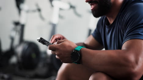hombre usando teléfono inteligente en el gimnasio