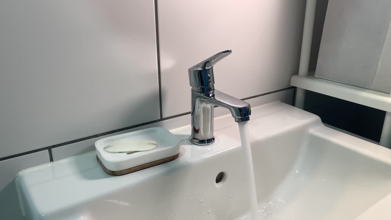 慢慢打開和關閉浴室的水龍頭