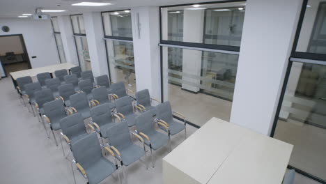 empty modern conference room with rows of chairs and glass partitions