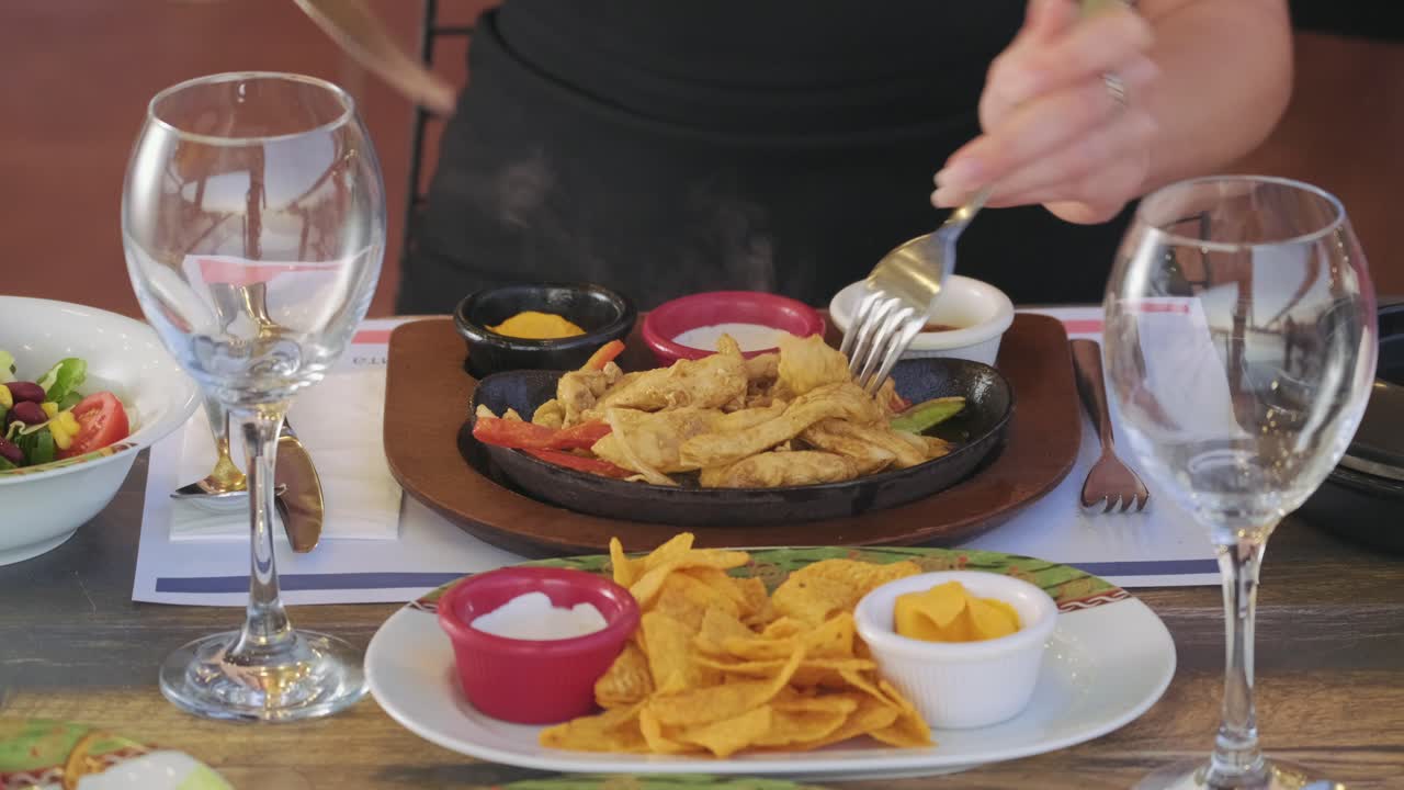 primer plano de manos femeninas cortando pollo en un plato